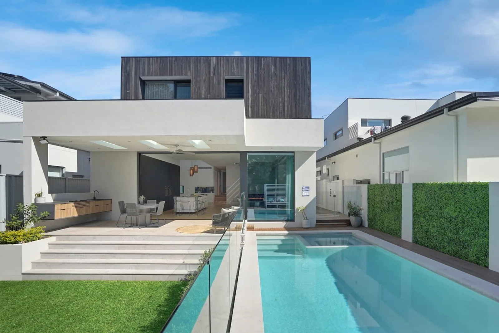 Street-facing exterior of the completed Concord House new build with rendered lower façade, dark upper-level cladding and minimalist entry fencing