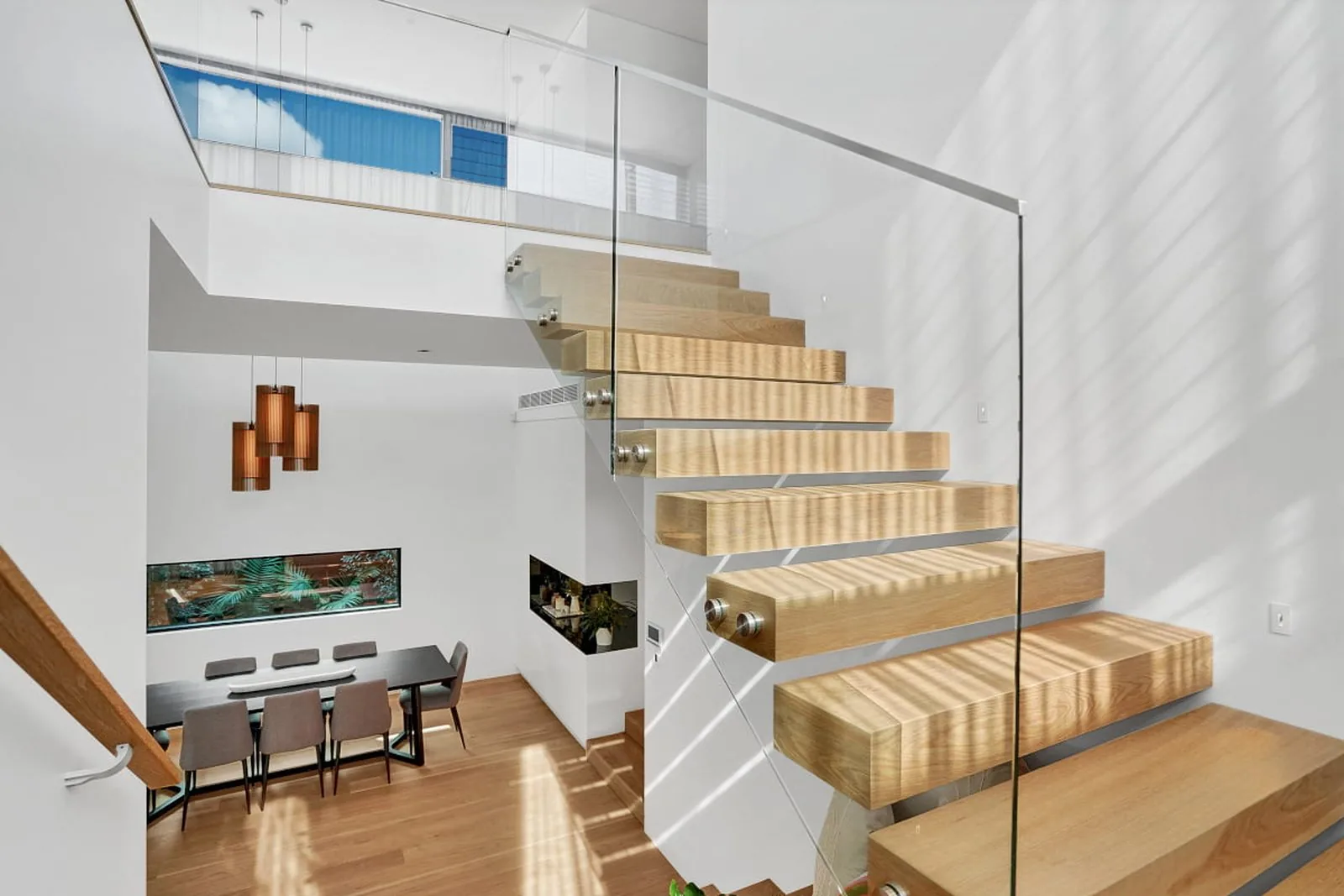Floating timber staircase with a frameless glass balustrade in a new family home