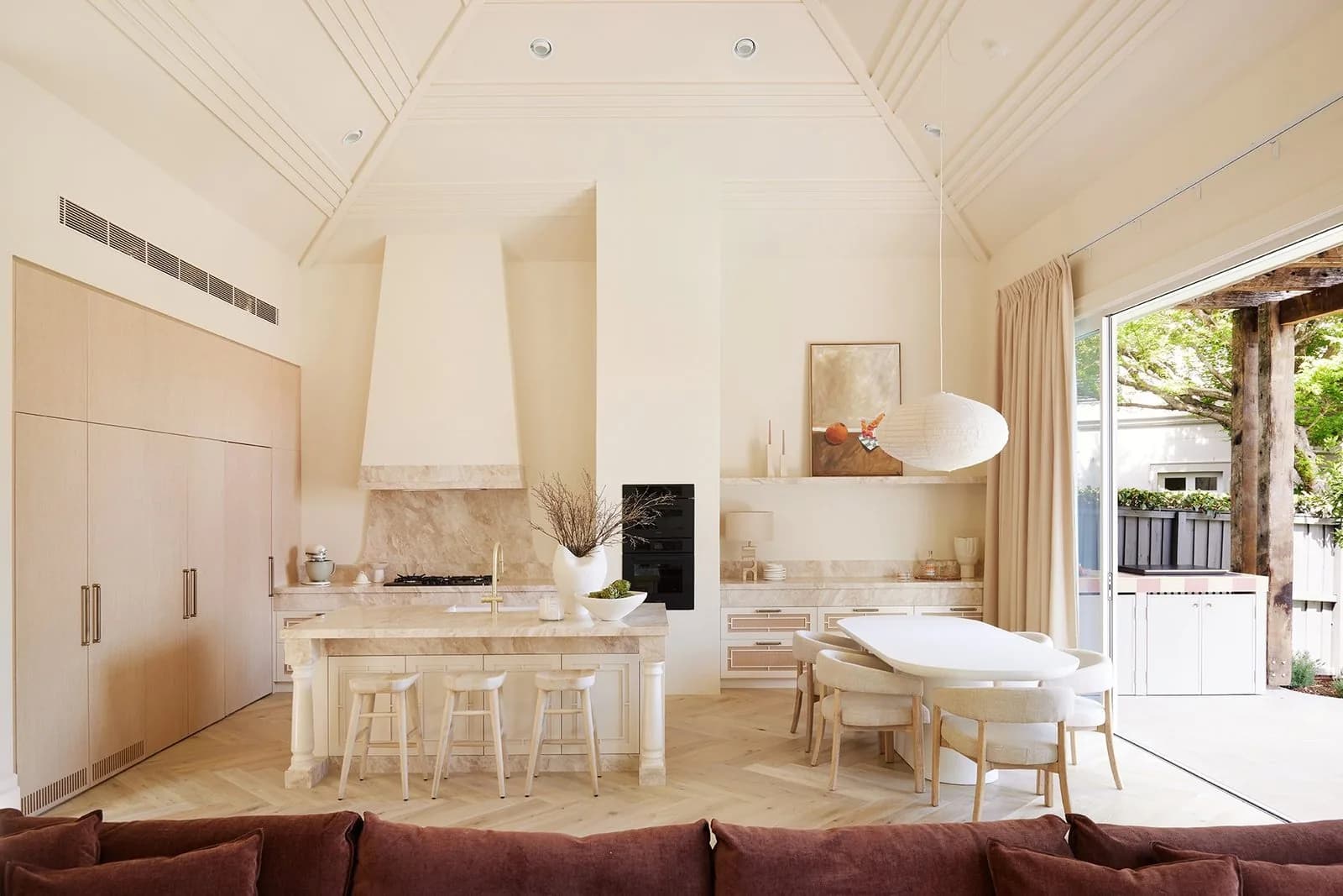 Light-filled kitchen and dining area with raked ceilings and custom joinery