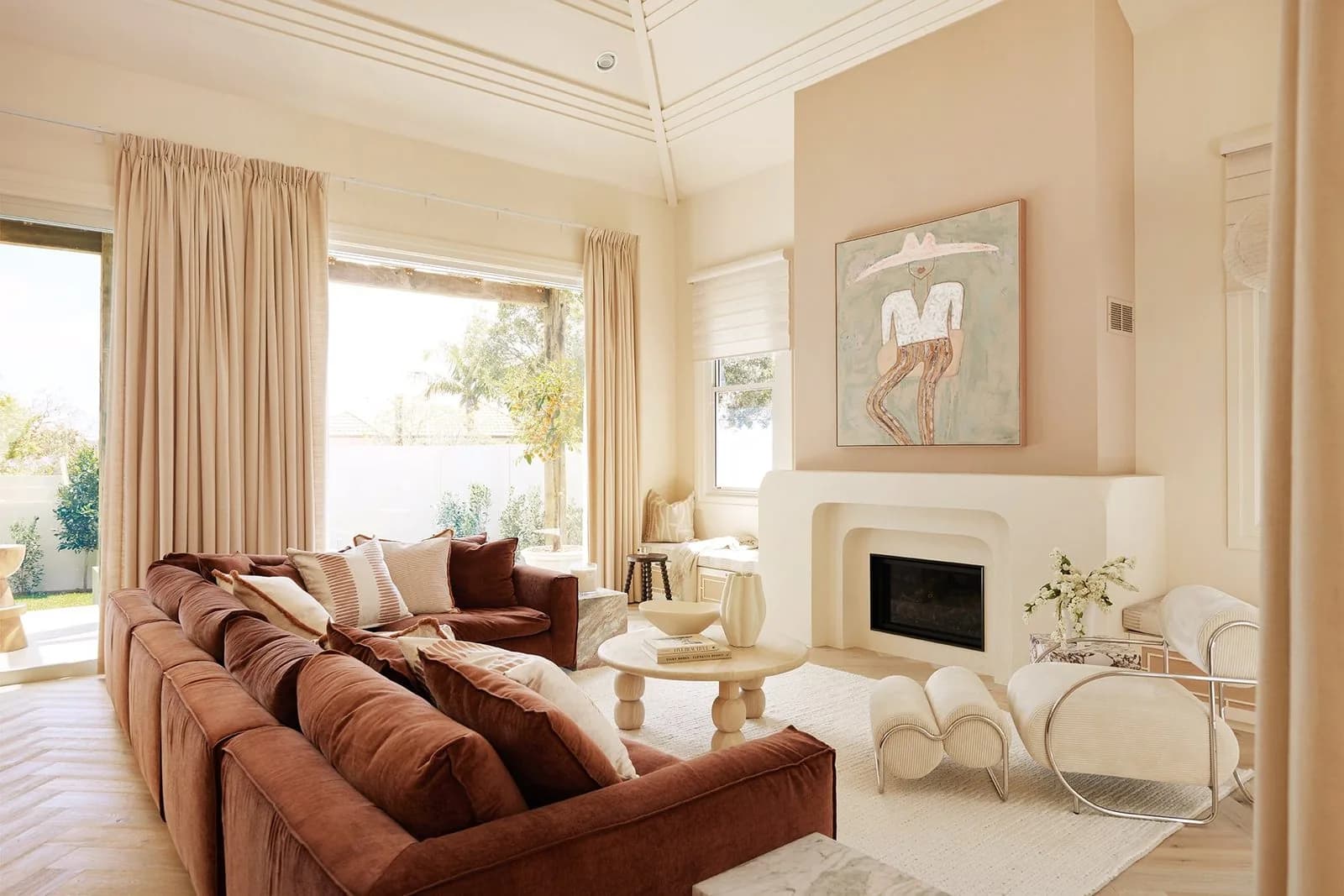 Renovated family living room with a raked ceiling, fireplace and a warm neutral palette
