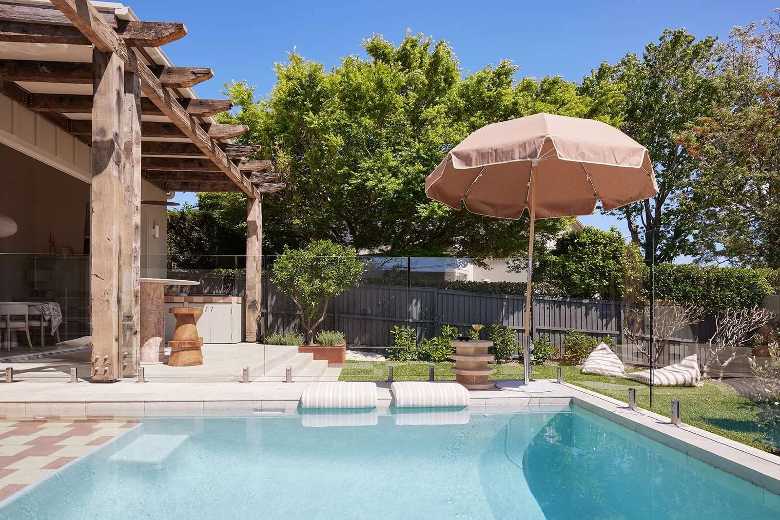 Landscaped pool area with glass fencing, lounges and connection to the alfresco zone