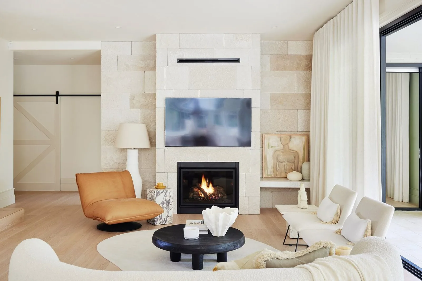 Extended living space with a stone fireplace wall connecting through to the outdoor alfresco area