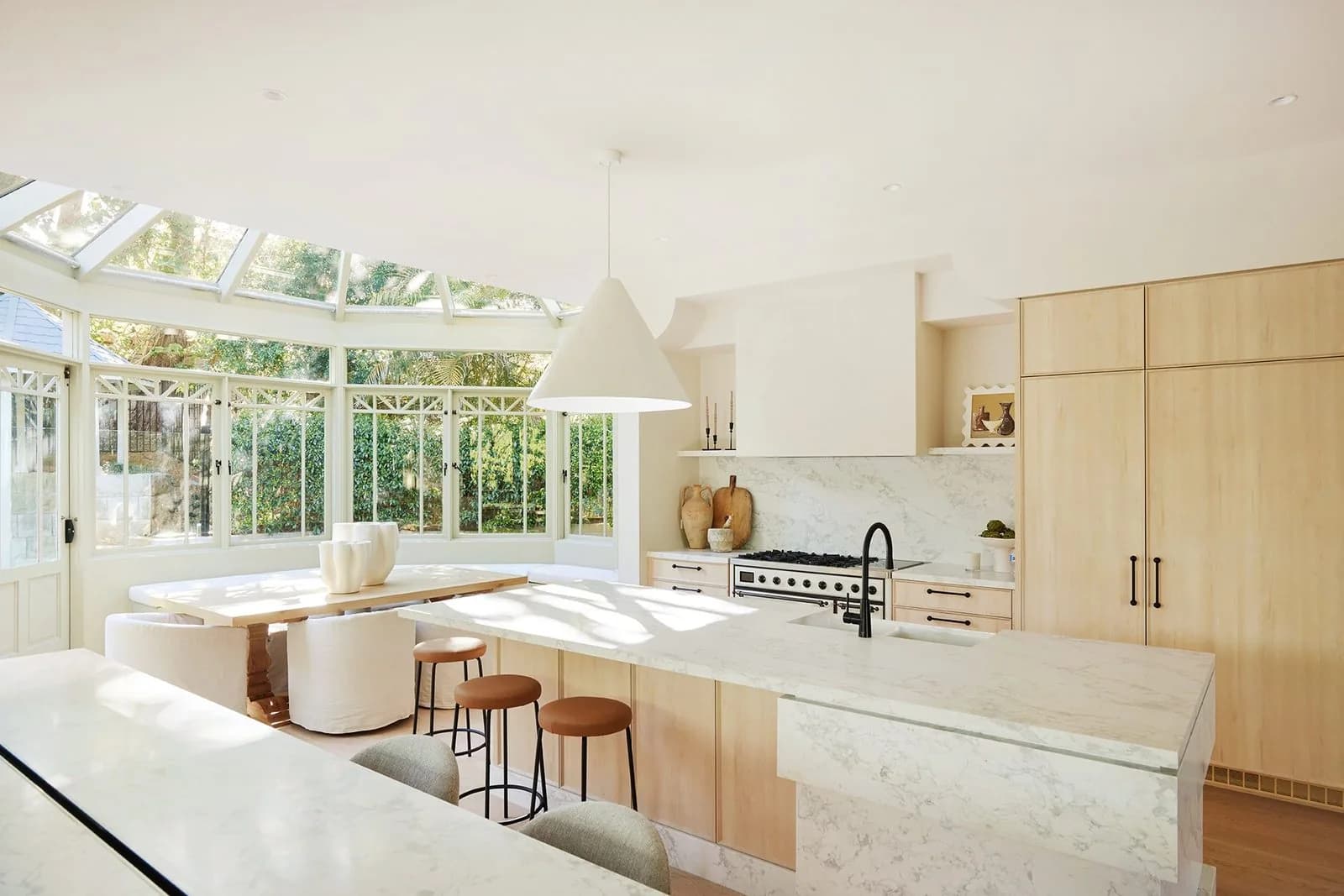Renovated kitchen and dining space with stone benchtops, timber joinery and black tapware